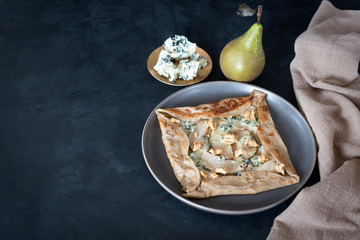 Galette bretonne with pear and gorgonzola cheese. Is a large buckwheat crepe that is stuffed with various savory fillings. - obrazy, fototapety, plakaty