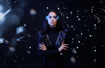 Beautiful woman in glasses of virtual reality on dark space magic background. Augmented reality, future technology concept. VR. Futuristic 3d glasses with virtual projection. Blue neon light.