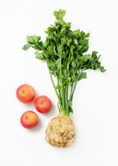 Top view of three apples and celery root and stem on a white background. Vegetables and fruits ingredients for the salad.