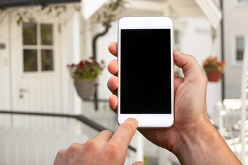 Businessman in suit holding phone in hands on background