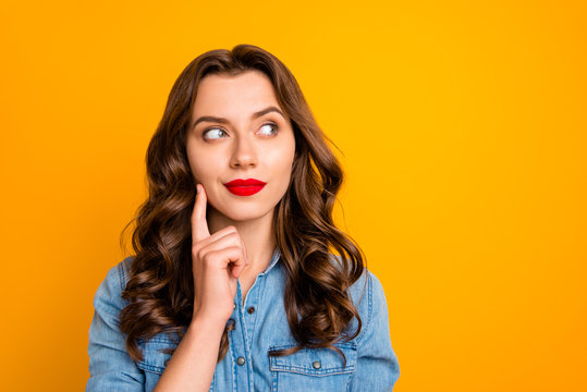 Photo of curly wavy trendy pensive youngster contemplating empty space above her isolated over yellow vivid color background