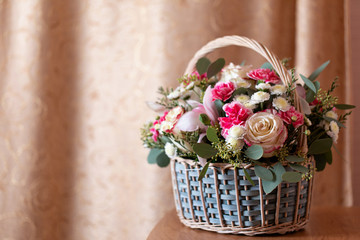 delicate flower arrangement. beautiful bouquet of pink flowers in basket on wooden table. wedding bouquet made by professional designer florist