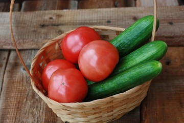 Fresh cucumbers and tomatoes on a wooden table
