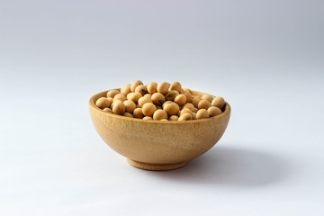 Closed up Isolate heap of yellow soy beans in mini wooden bowl. The best protein from natural and meal for vegan. Food in the vegetarian festival are coming.