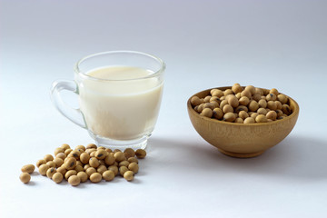 Closed up heap of soy beans on white floor and mini wooden bowl. The benefit of soy beans so much and popular for made some soy milk. This is the important ingredients for vegtarian.