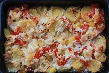 Baked potatoes with chicken and tomatoes close up