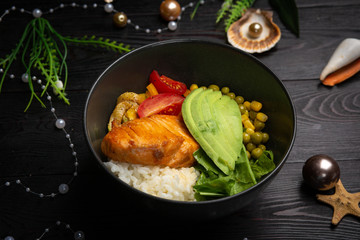 bowl with salmon in a black plate on a dark wooden background
