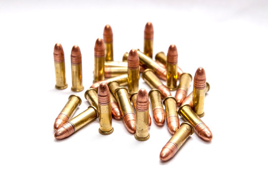 A group of .22 caliber full metal jacket bullets on a white background