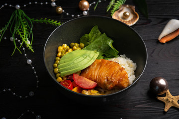 bowl with salmon in a black plate on a dark wooden background