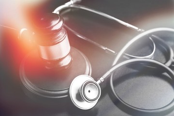 Wooden gavel and stethoscope on wooden background