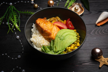 bowl with salmon in a black plate on a dark wooden background