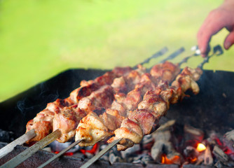 Roasting meat on skewers on the grill in the fresh air in sunny weather