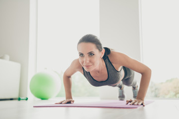 Full body photo of active positive brown hair sporty girl doing crossfit plank exercise want become strong slim beauty practice feel vitality on purple mat in house studio-like gym indoors