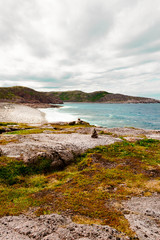 Obraz premium Beautiful summer day North landscape waves, foam and spray Barents sea Teriberka view.