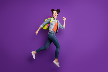 Fototapeta na wymiar Shopping time. Full size profile photo of funny student lady jumping high glad to finish study rushing mall wear green bag casual denim outfit isolated purple color background