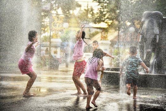 children playing in water fountain