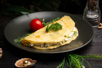 Chinese onion tortilla with cottage cheese and herbs in a black plate