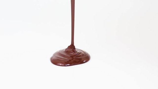 Melted chocolate is poured on a white surface.