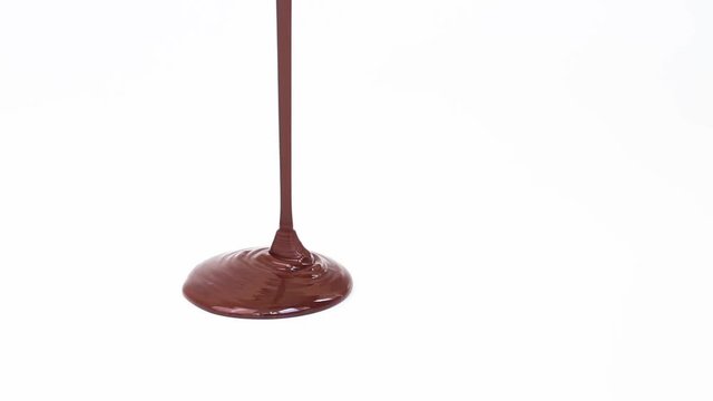 Melted chocolate is poured on a white surface.