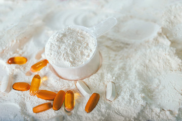 Whey protein scoop and food supplement tablets. Sports nutrition.
