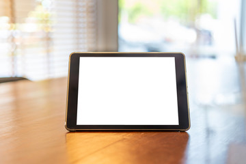 Mockup tablet like ipad stan on th wooden desk in office background with white screen clipping path