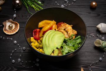 shrimp bowl with avocado in a black plate