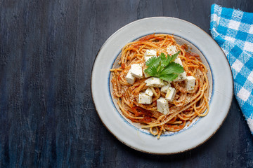 Spaghetti pasta with fresh and parmesan cheese on dark background