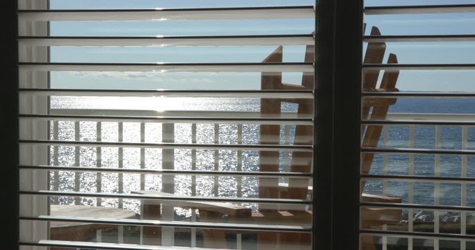 Ocean View through Window Slats During Evening with Chair