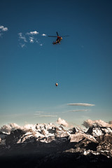 Fototapeta na wymiar Helicopter Flying Over Mountains Against Sky During Sunset