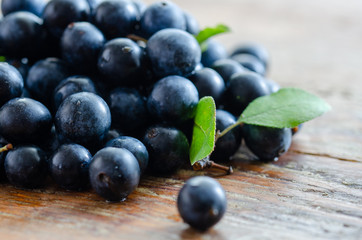 Blueberries with blueberries leaves  on the wooden table.