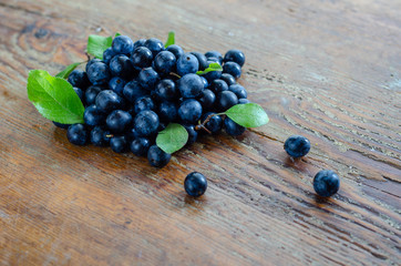 Blueberries with blueberries leaves  on the wooden table.