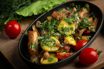 roast lamb in a black oval plate on a wooden board on a dark background