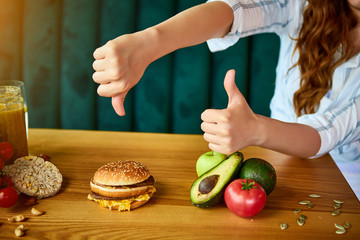 Woman is refusing to eat unhealthy hamburger. Cheap junk food vs healthy diet