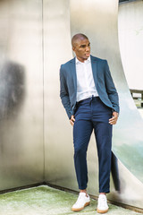 Portrait of Young African American Man in New York City. Wearing blue blazer, white shirt, blue...