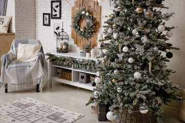 Modern black and white interior design room with Christmas and New Year decorations, toys, gifts, snow-covered fir tree, garlands. Winter holidays composition.
