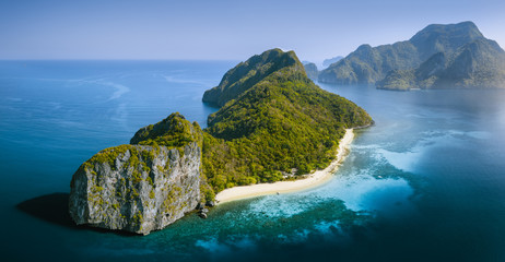 Drone Aerial Panorama image of Helicopter Island in the Bacuit Bay in El Nido, Palawan, Philippines lit by morning sunrise light