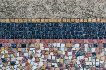 Close up on old worn and weathered Ancient mosaic tiles design on the ground 