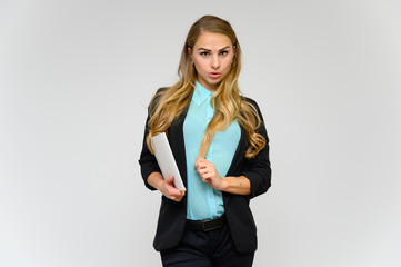 Portrait of a pretty blonde girl financial secretary with long curly hair in a business suit standing in the studio on a white background with emotions in different poses with a folder in his hands.