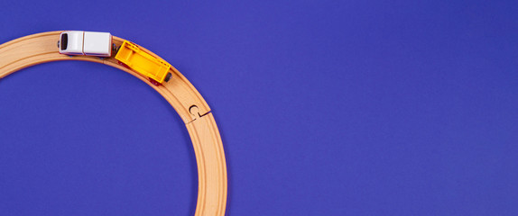 Toy train and wooden rails on blue color background