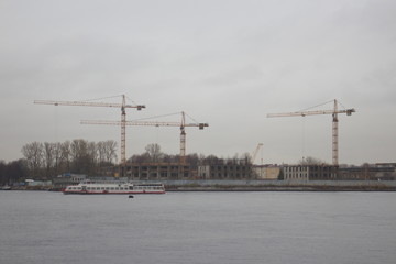 Fototapeta na wymiar tower cranes on the shore on a cloudy day