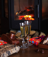 Glasses of drink are on the table by the fireplace