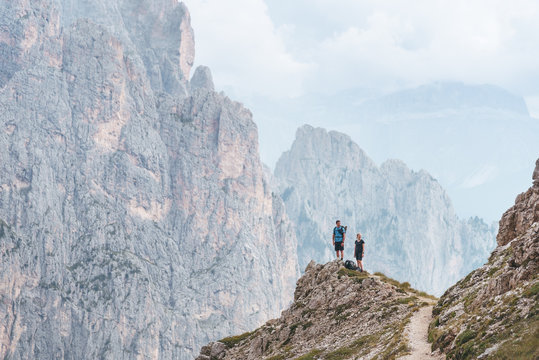 two hikers on a mountain ridge in the dolomites