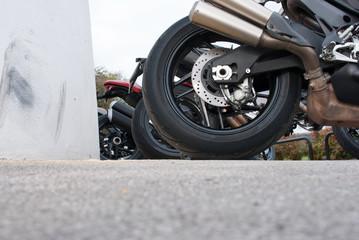 Low angle of motorbikes parked near a wall showing tyres