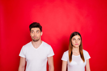 Photo of pensive thinking wondered couple suspecting each other with faces expressing thoughtfulness with bristle wearing white t-shirt isolated vivid color background