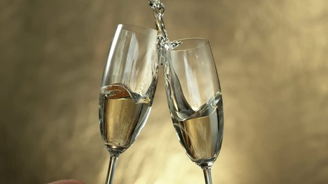 Super slow motion of having a toast with two champagne glasses with speed ramping effect. Filmed on high speed cinema camera, 1000fps