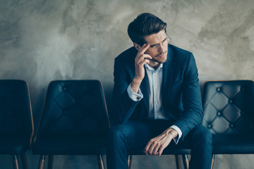 Portrait of upset collar man sit on chair wait for boss human resources worker feel nervous about meeting wear modern classy jacket trousers isolated over grey color background