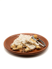 plate with nougat and tongs on white background, christmas food