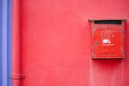 Red mail box.  Red decorative mailbox in the village of Burano in Venetian Lagoon. Colourful post box in Burano, Italy.