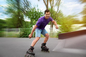 Handsome young man roller skating in park