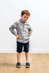sulking conflicted boy standing with hands on hips expressing attitude